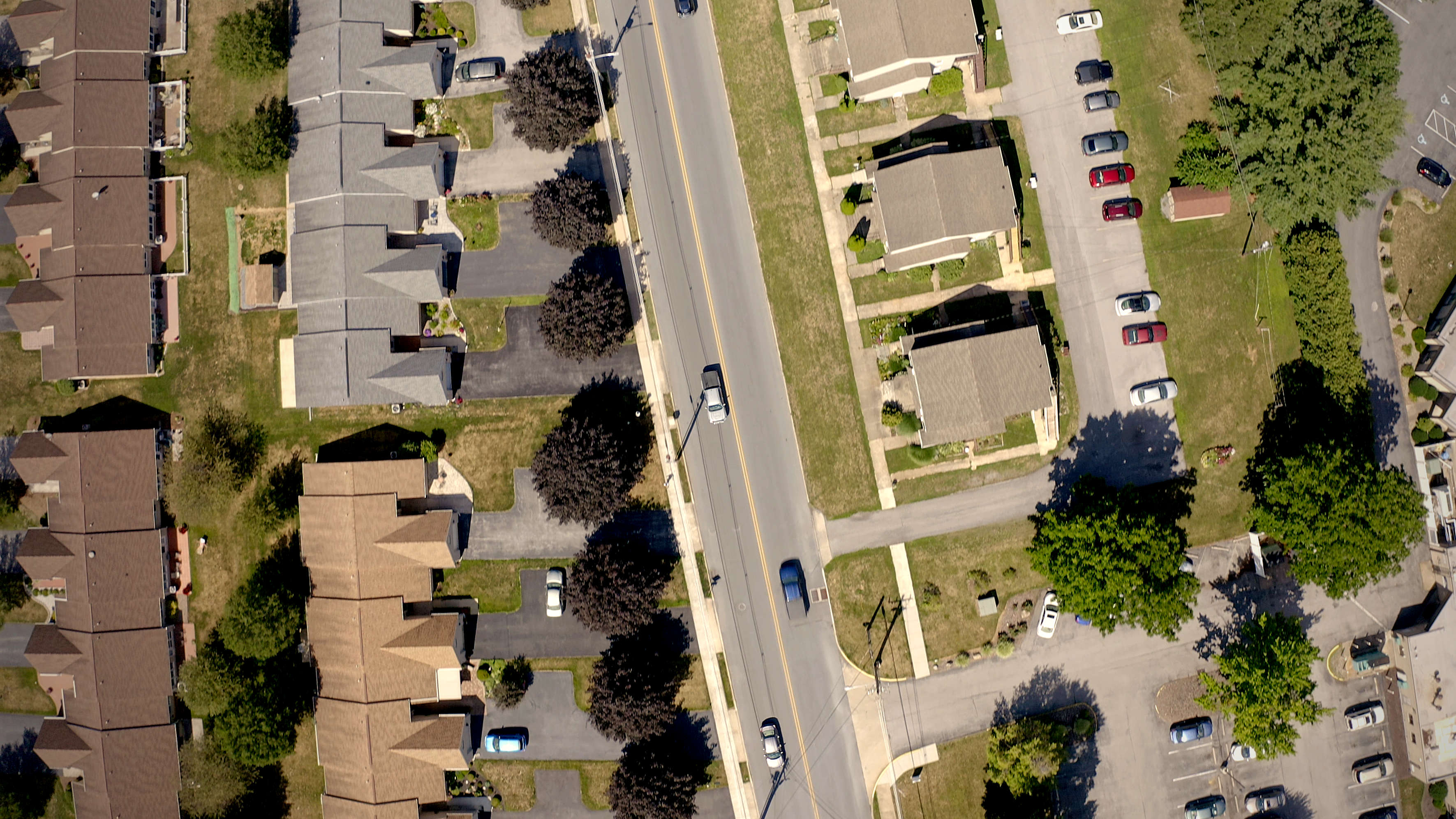 Drone video tracking car through suburban neighborhood