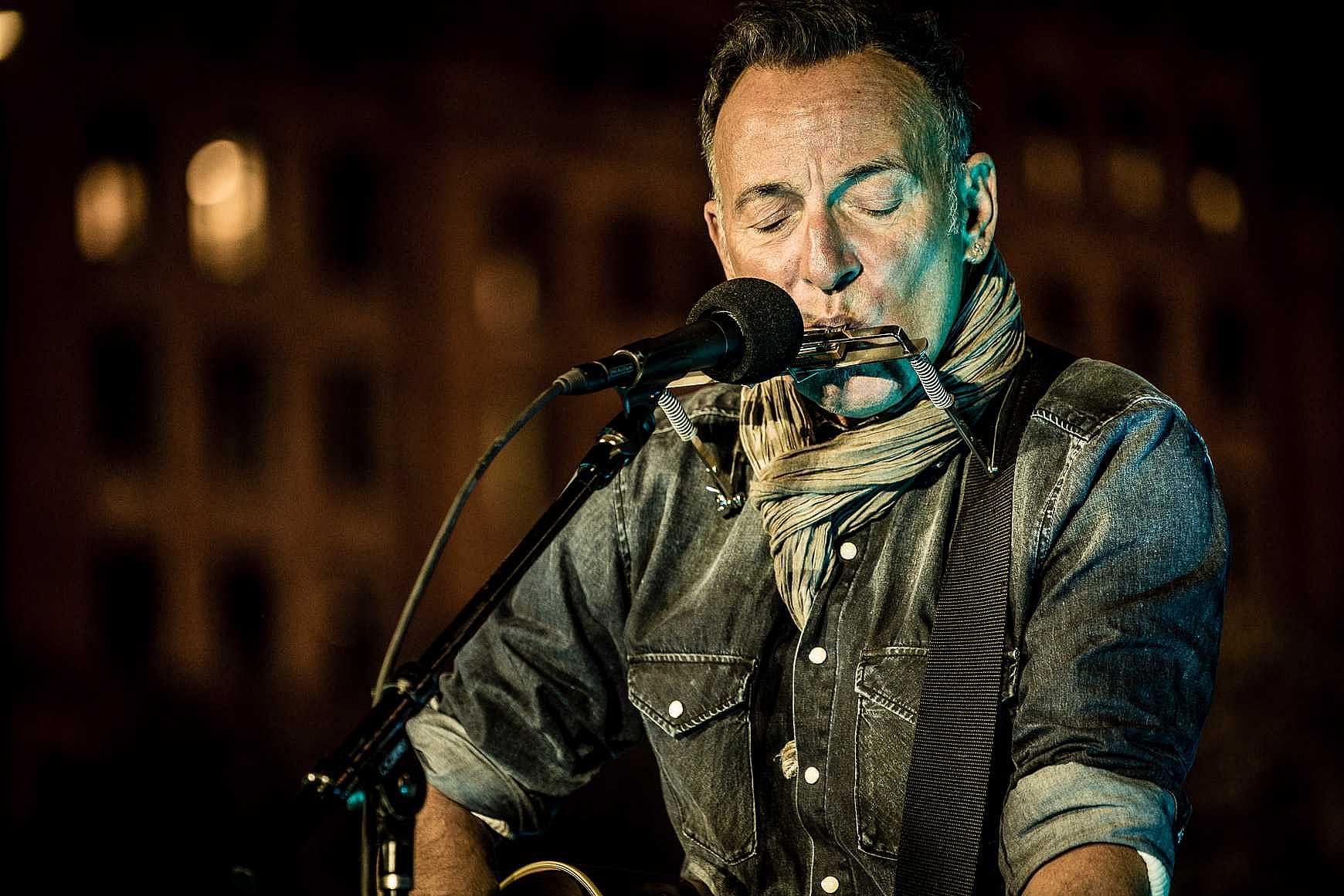 Bruce Springsteen play harmonica and guitar