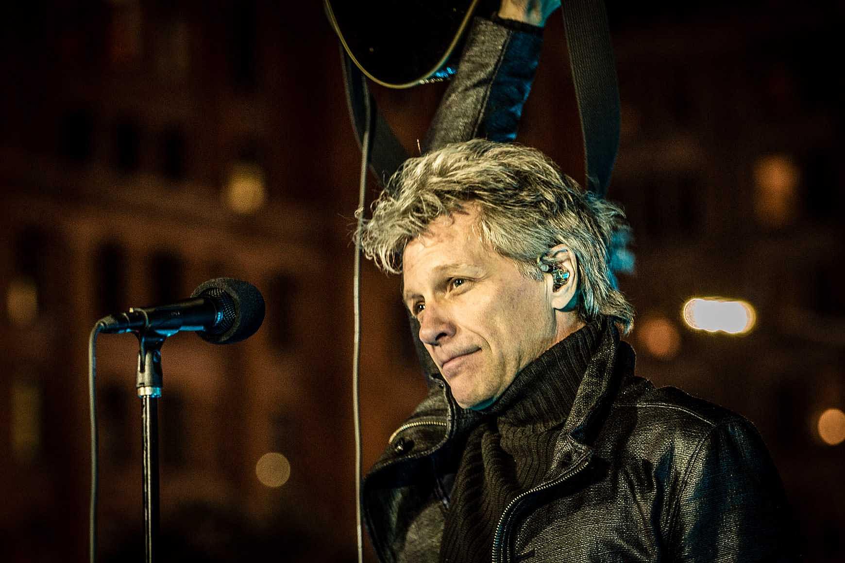 Jon Bon Jovi holds guitar above head